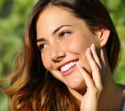 Beauty woman with a perfect smile and white tooth with a green background